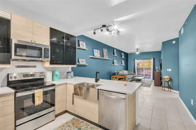 a view of a kitchen with a stove cabinets and a view of living room