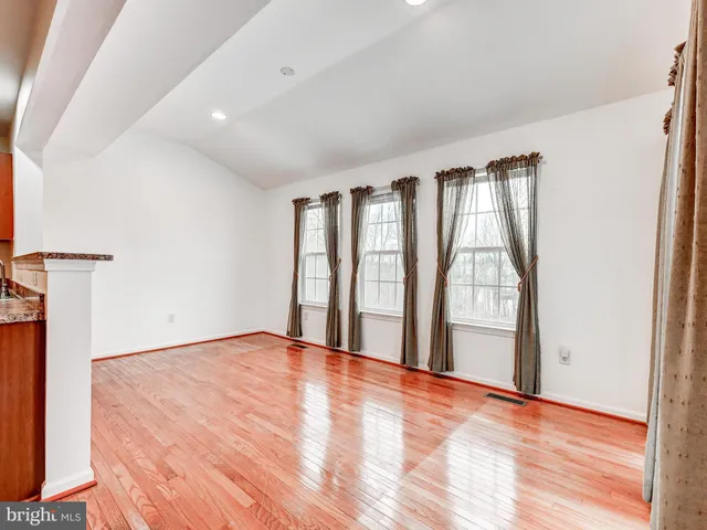 an empty room with windows and fireplace