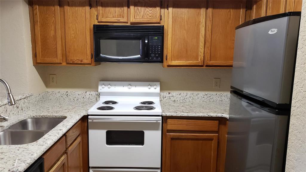9811 Walnut Street, Unit 108 Dallas, TX 75243 - Photo 4 of 12 a kitchen with a stove microwave and sink