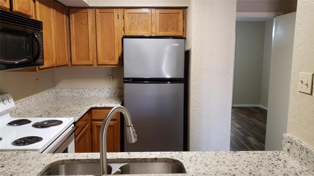 9811 Walnut Street, Unit 108 Dallas, TX 75243 - Photo 5 of 12 a view of kitchen with a sink stove and refrigerator