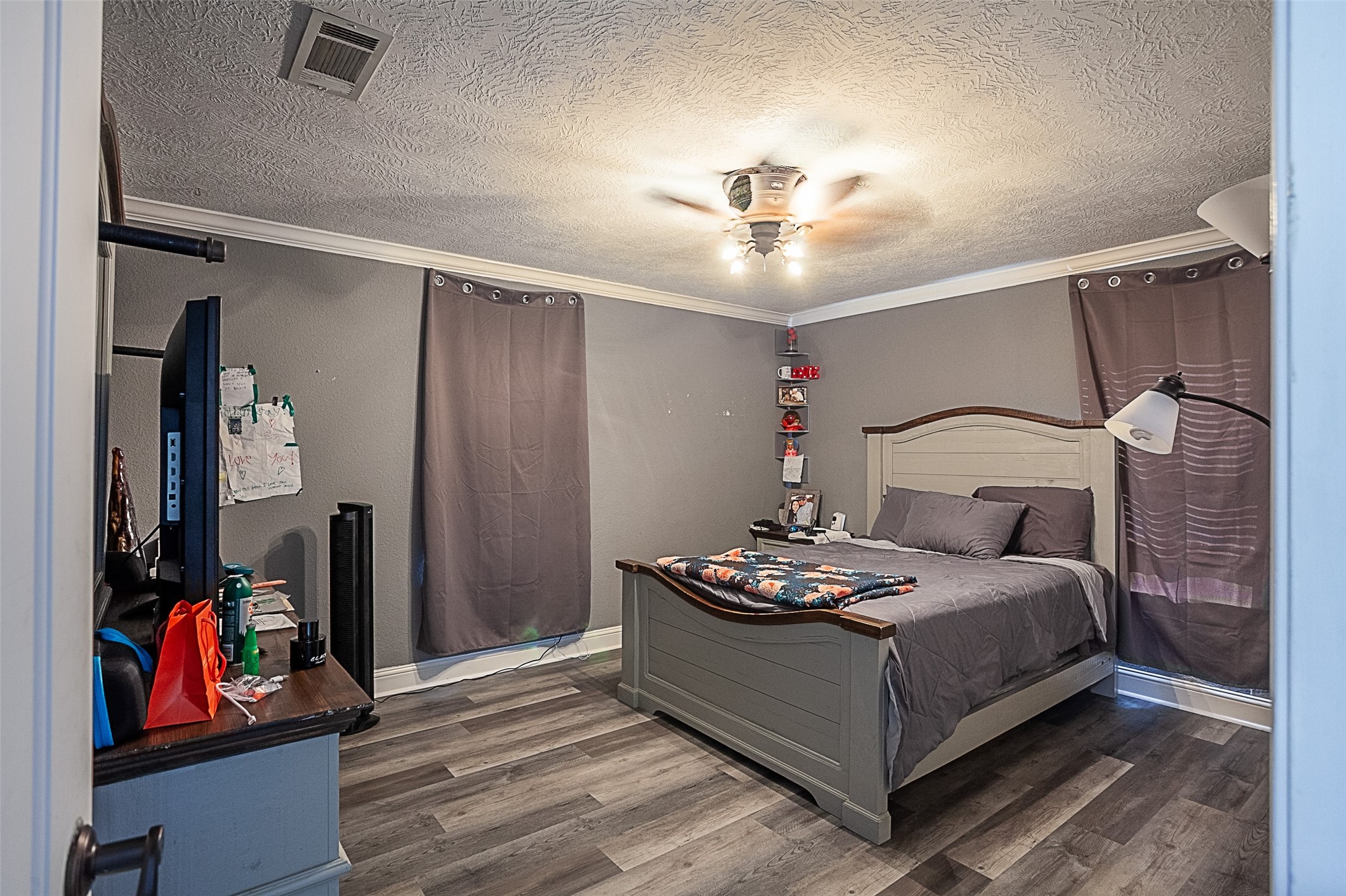 120 Mayflower Street Bridge City, TX 77611 - Photo 12 of 27 a bedroom with a bed and dresser with wooden floor