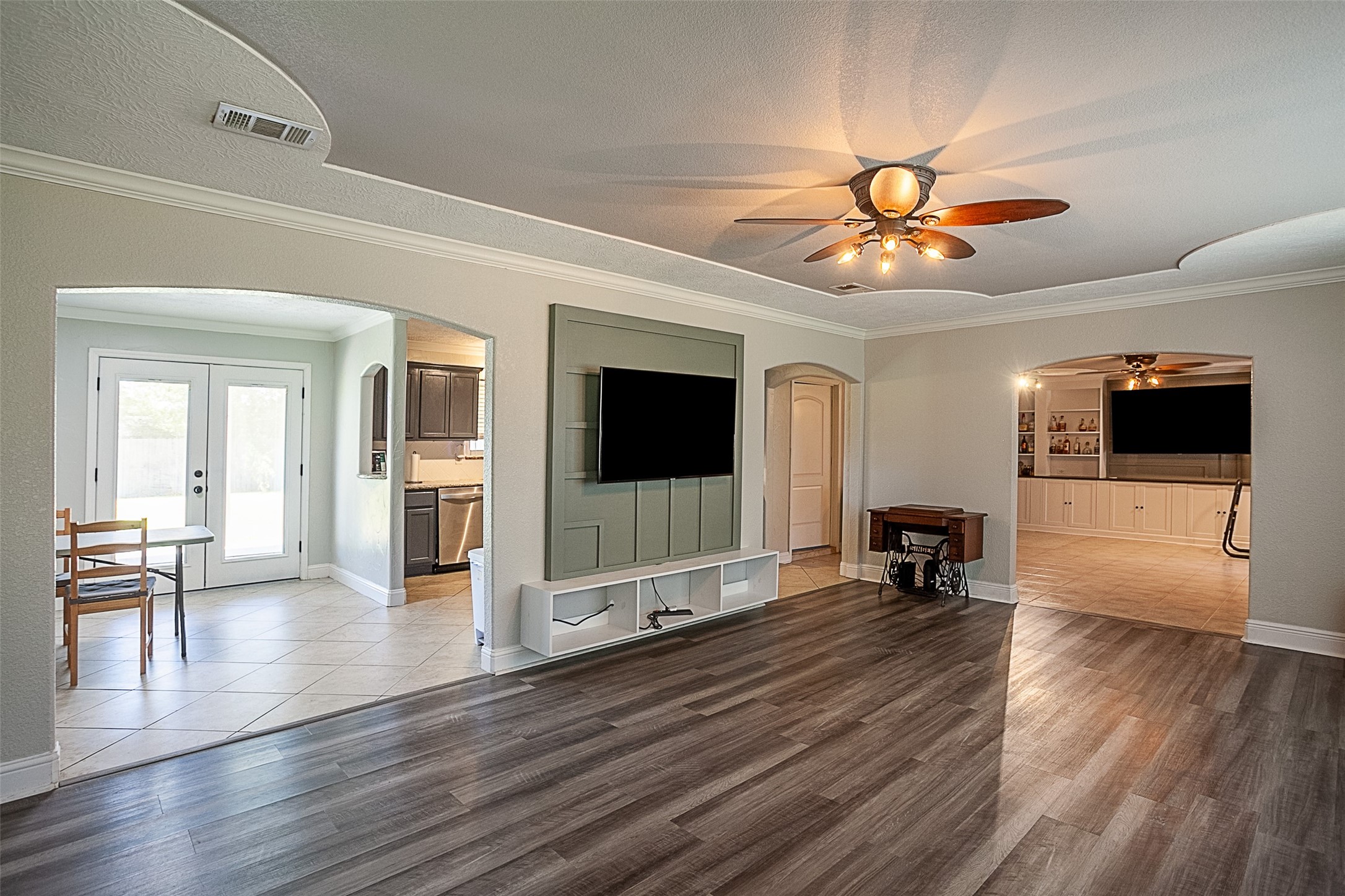 120 Mayflower Street Bridge City, TX 77611 - Photo 4 of 27 a view of a livingroom with a flat screen tv wooden floor and a ceiling fan