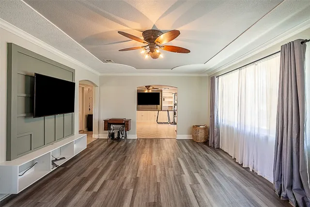 a view of a livingroom with furniture window wooden floor and a ceiling fan