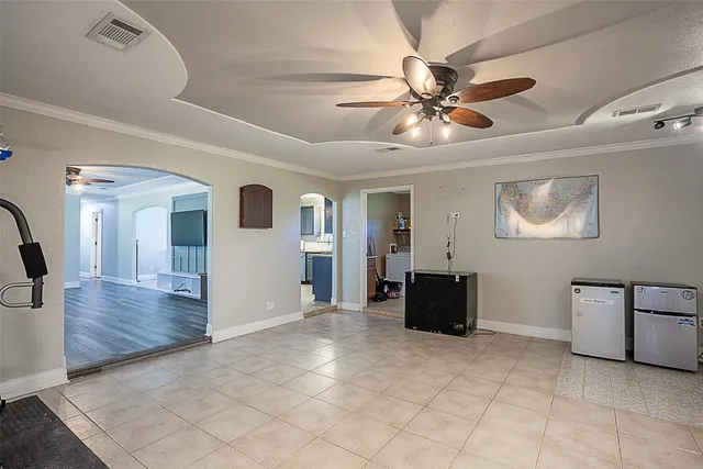 a view of a livingroom with furniture cabinet a ceiling fan and wooden floor