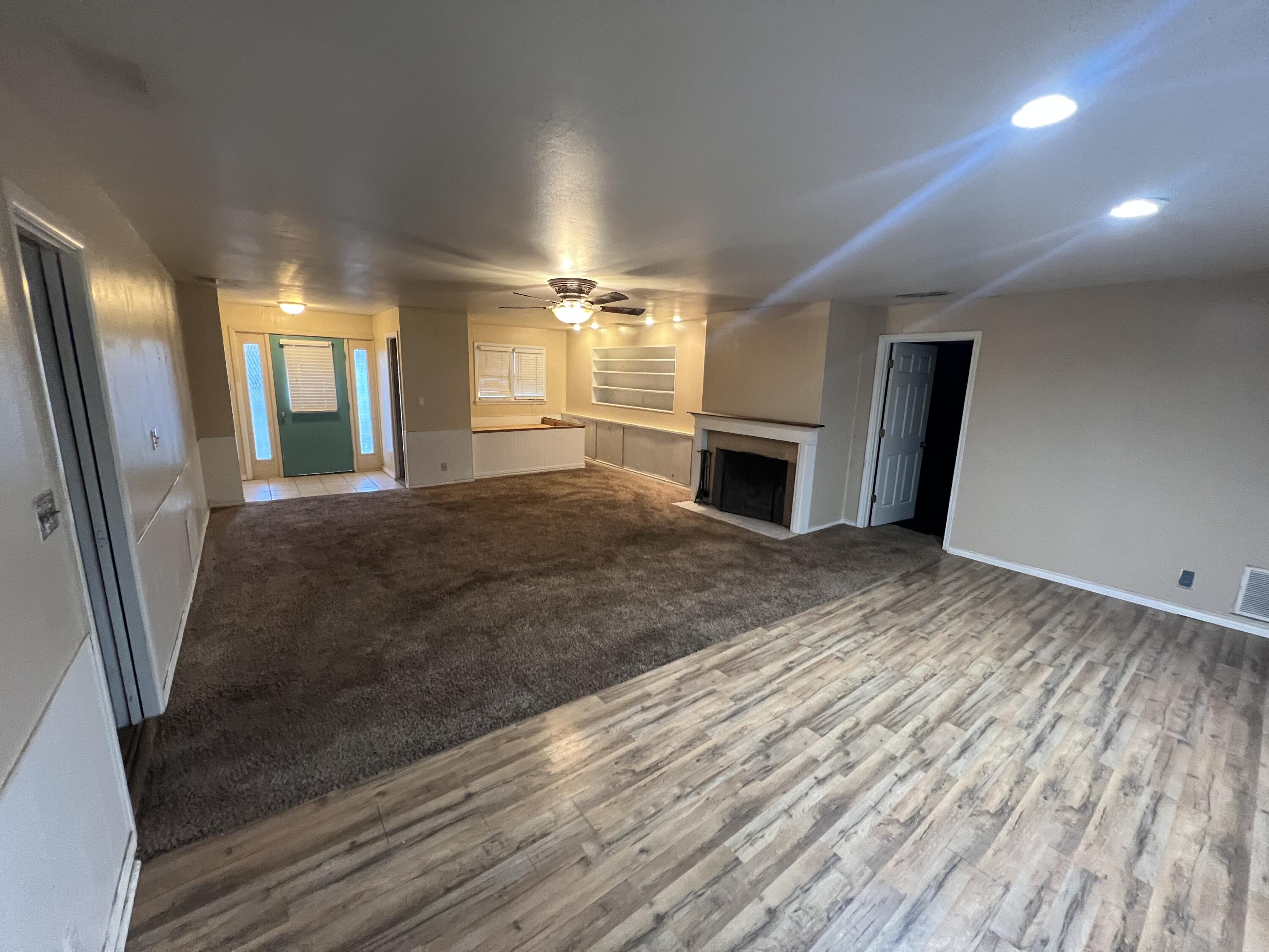 203 Northeast Alpine Plainview, TX 79072 - Photo 14 of 15 wooden floor in an empty room with a fireplace