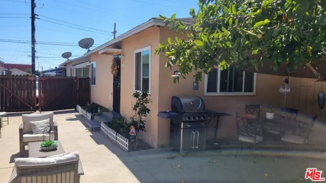 a patio with table and chairs and potted plants