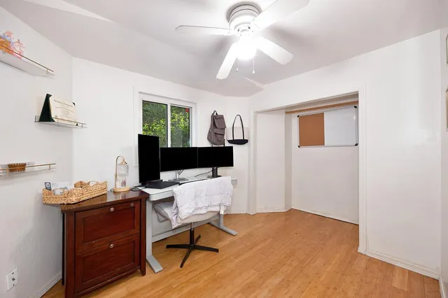 a view of a workspace with furniture and a window