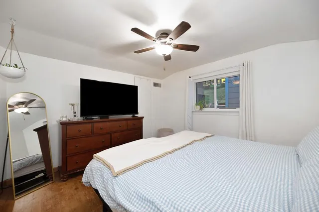 a bedroom with a bed a flat screen tv and a chandelier