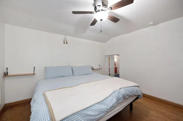a bedroom with a large bed and a chandelier