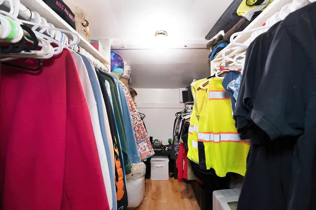 a view of walk in closet with clothes and shoes
