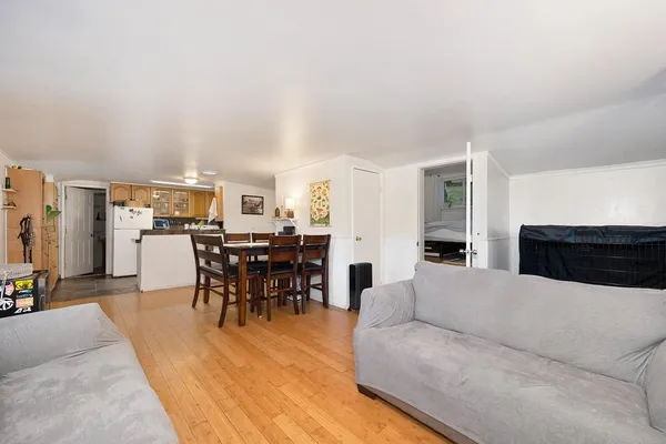 a living room with furniture a view of dining room and kitchen view