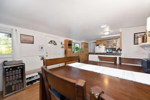 a room with stainless steel appliances kitchen island granite countertop a table chairs and a refrigerator