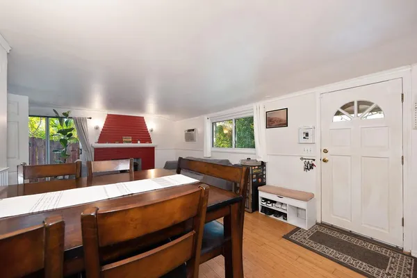 a room with a table chairs and a window