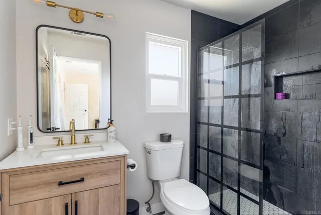 a bathroom with a toilet a sink and mirror