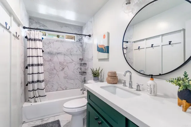 a bathroom with a sink toilet mirror and shower
