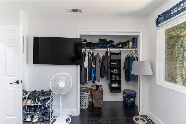 a view of walk in closet with clothes and shoes