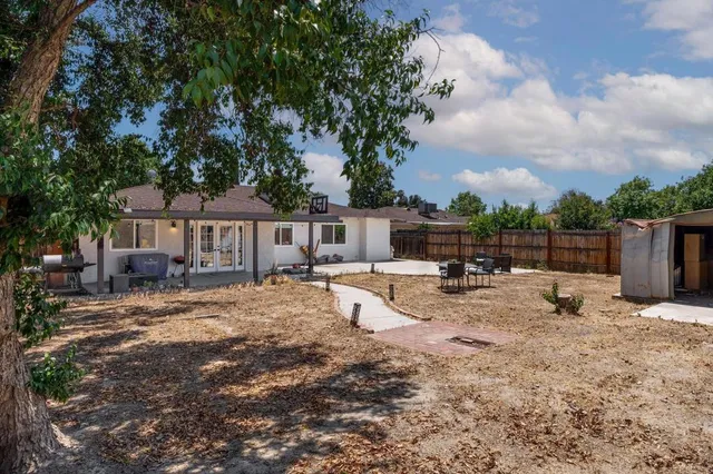 a view of a house with backyard and sitting area
