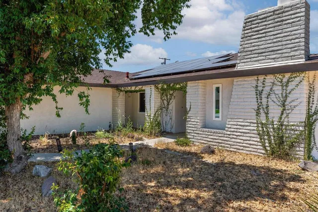 a backyard of a house with table and chairs