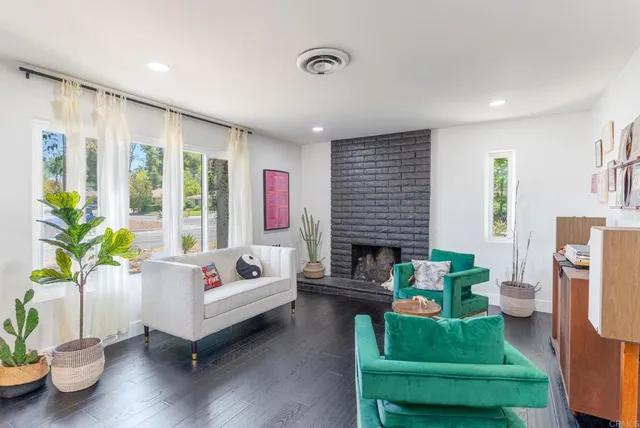 a living room with furniture fireplace and a potted plant