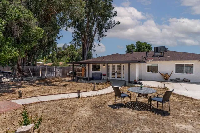a view of a house with backyard and sitting area