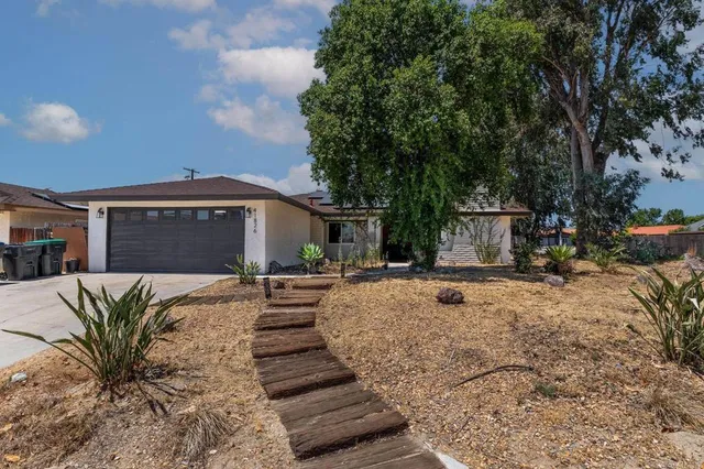 a view of a house with backyard and sitting area