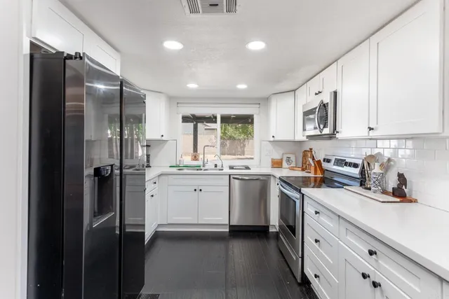 a kitchen with a refrigerator sink and cabinets