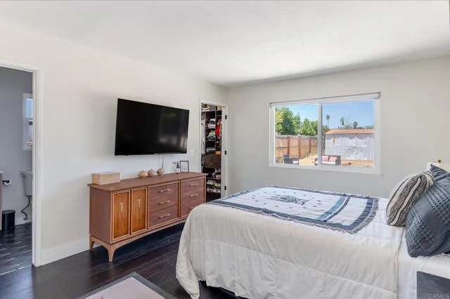 a bedroom with a flat screen tv and a bed