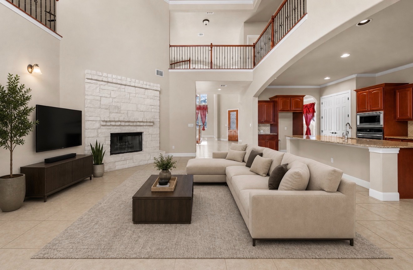 3903 Remington Road Cedar Park, TX 78613 - Photo 7 of 29 A spacious living area unfolds, featuring high ceilings and a grand fireplace, flowing into a well-appointed kitchen.