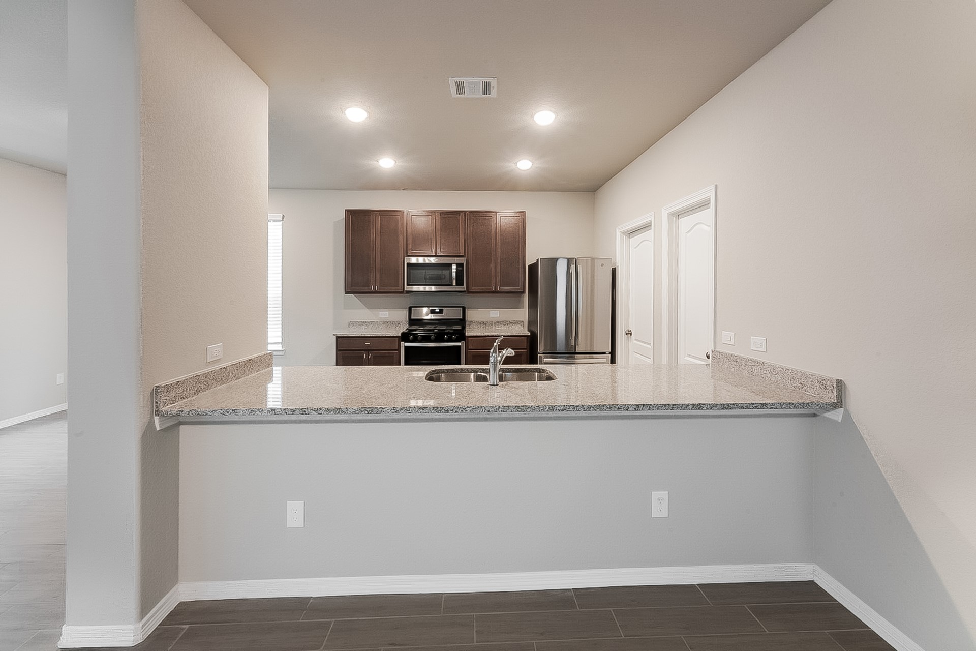 25542 Valverdant Court Porter, TX 77365 - Photo 8 of 17 a view with kitchen island a sink and wooden cabinets