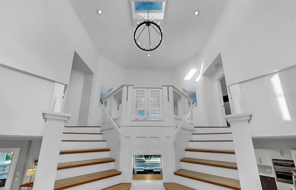 945 Bunker View Drive Apollo Beach, FL 33572 - Photo 14 of 92 a view of staircase with white walls and a chandelier