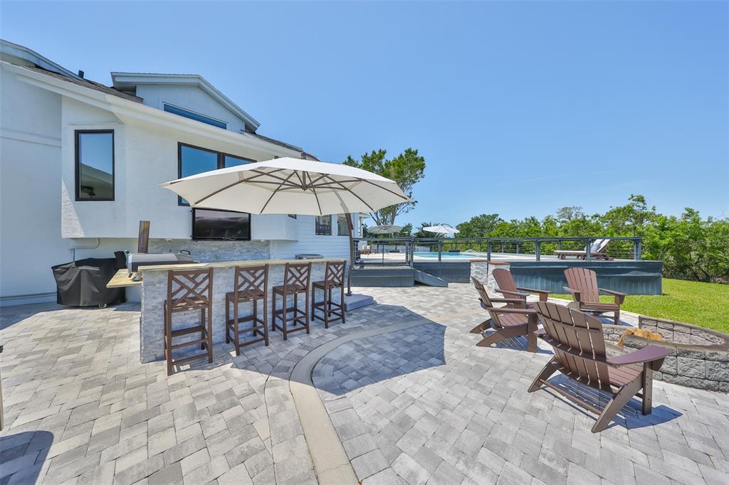 945 Bunker View Drive Apollo Beach, FL 33572 - Photo 84 of 92 a view of a patio with a table and chairs under an umbrella