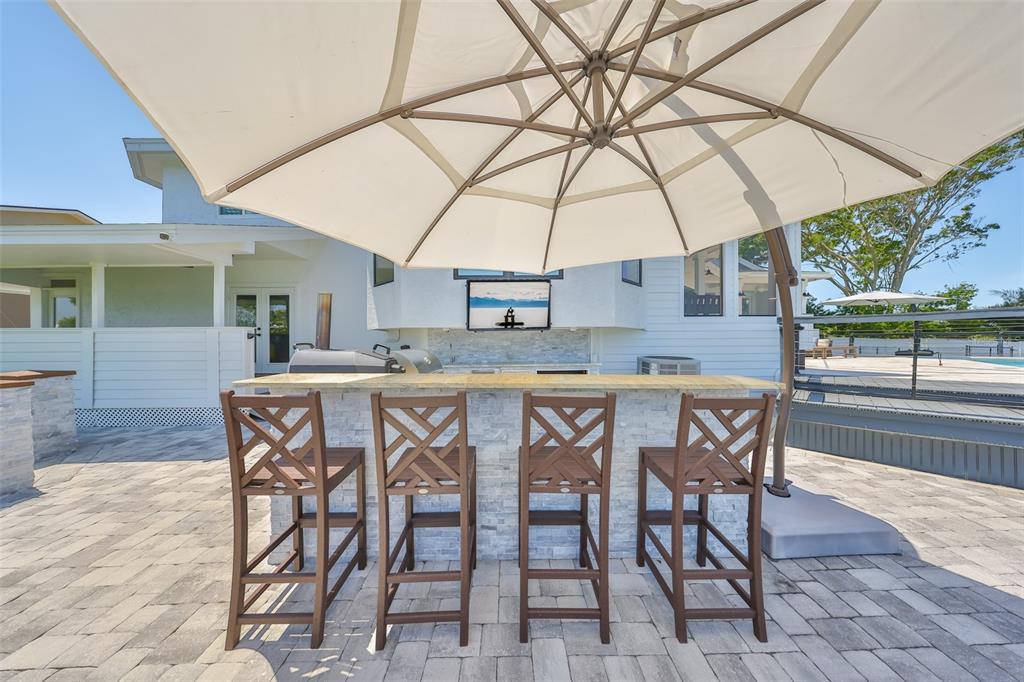 945 Bunker View Drive Apollo Beach, FL 33572 - Photo 85 of 92 a dining area with a table and chairs under an umbrella