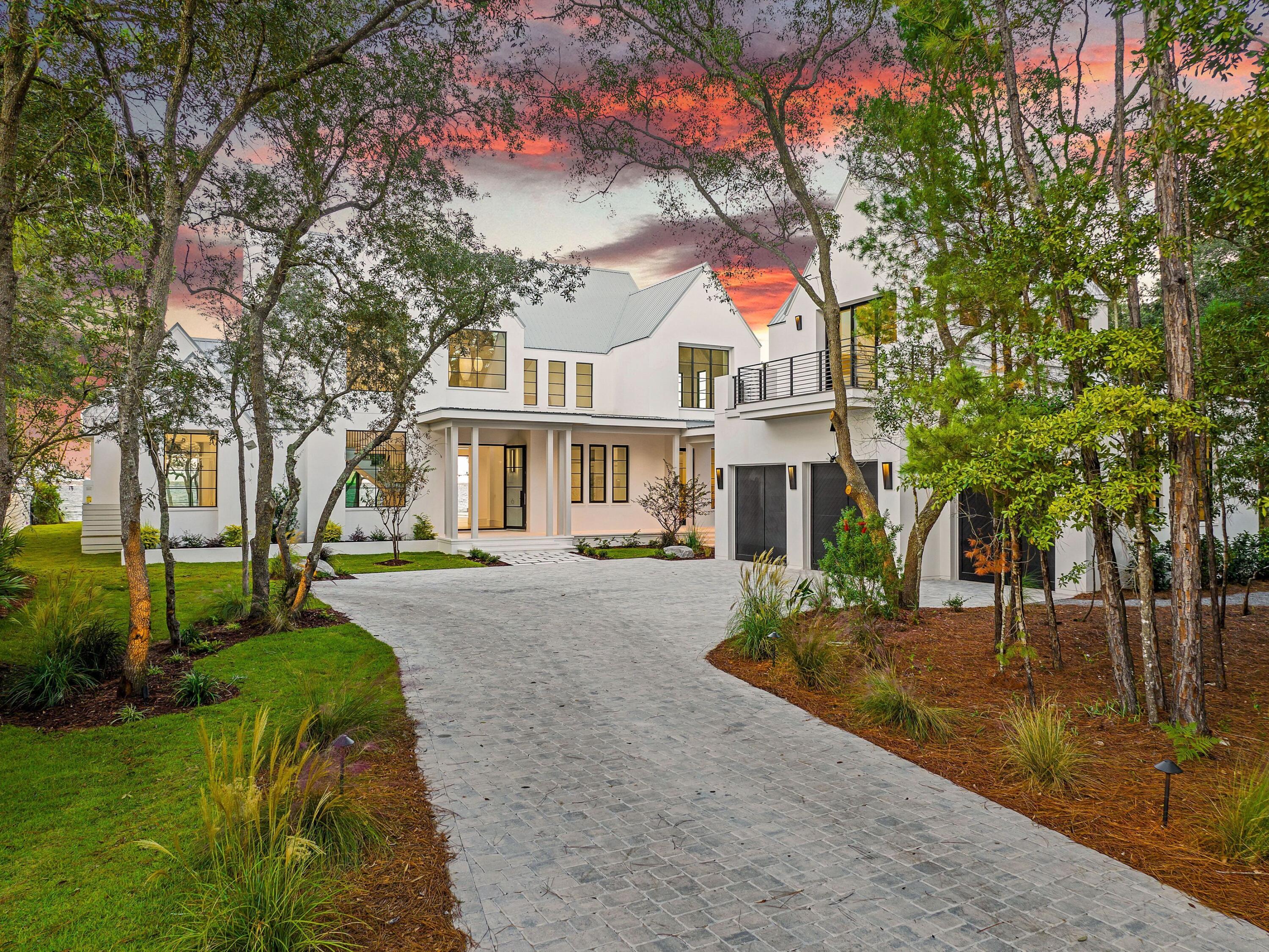 431 Pisces Drive Santa Rosa Beach, FL 32459 - Photo 2 of 48 a view of a white house next to a yard with plants and trees