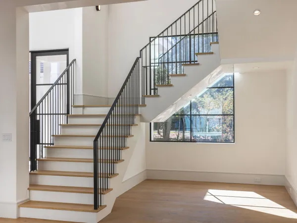 a view of staircase with wooden floor and a front door