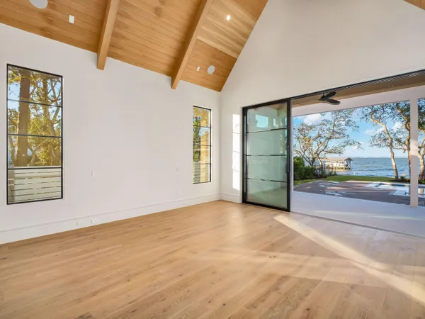 an empty room with wooden floor and windows