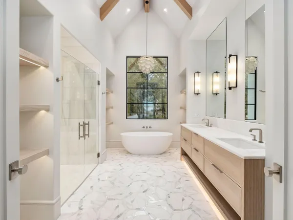 a bathroom with a bathtub a sink and a large mirror