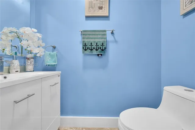 a white toilet sitting next to a bathroom sink