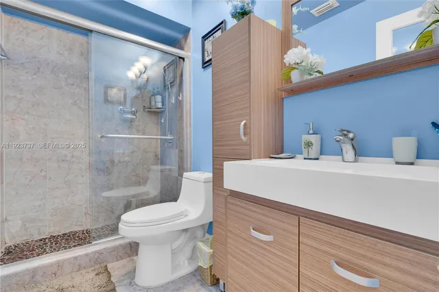 a bathroom with a sink a toilet and shower