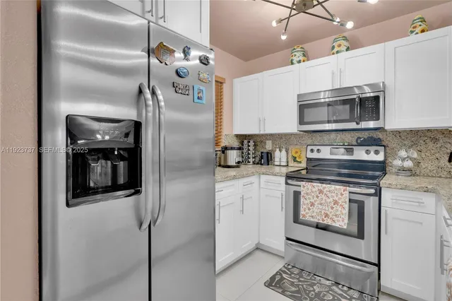 a kitchen with stainless steel appliances granite countertop a refrigerator a stove and a microwave