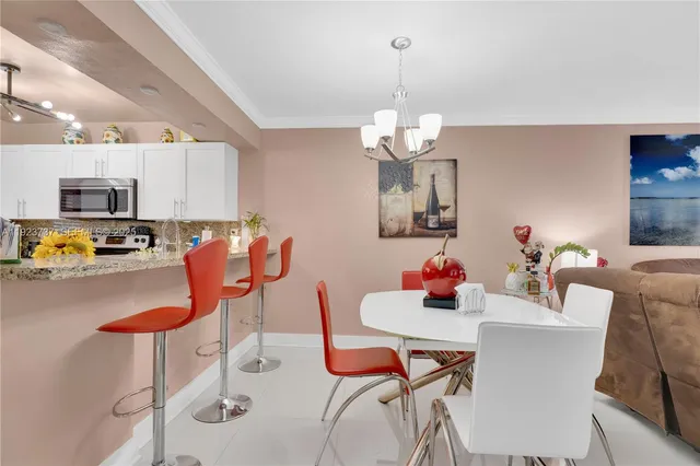 a dining room filled chandelier and wooden furniture