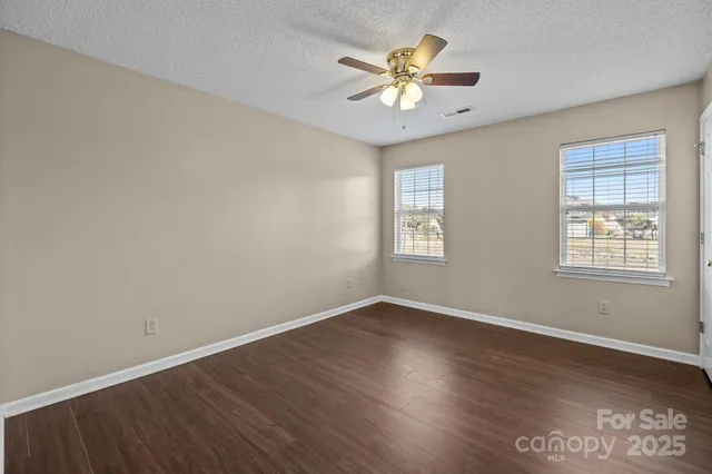 a view of an empty room with a window and a chandelier