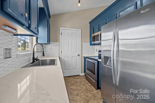 a kitchen with a refrigerator sink and stainless steel appliances