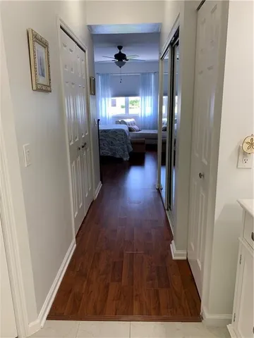 a view of a hallway to a livingroom with furniture wooden floor and windows