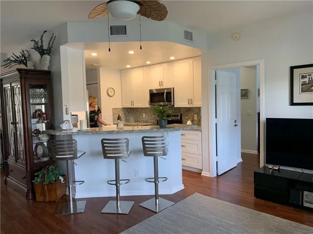 a kitchen with stainless steel appliances kitchen island granite countertop a refrigerator and a stove top oven