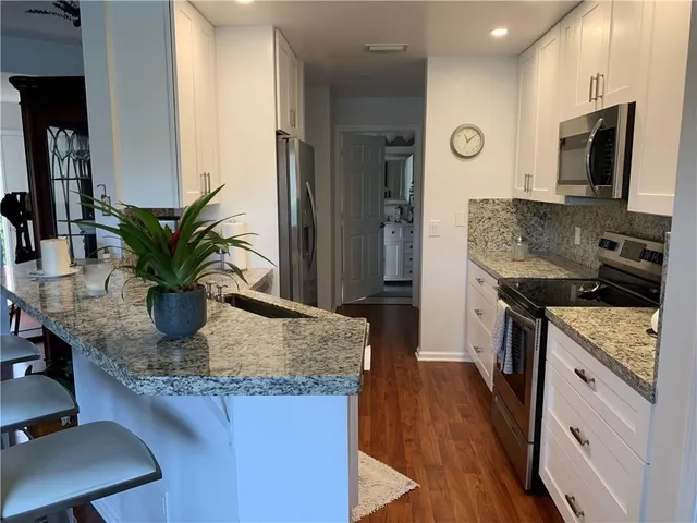a kitchen with stainless steel appliances granite countertop sink stove and refrigerator