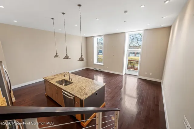 a view of a hallway with bathroom and wooden floor