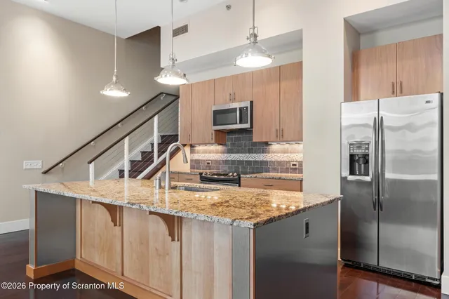 a large white kitchen with a large window a stove and a refrigerator
