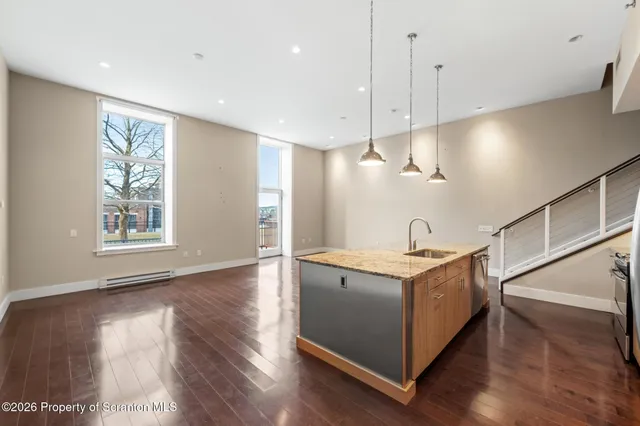 a view of entryway and kitchen with wooden floor