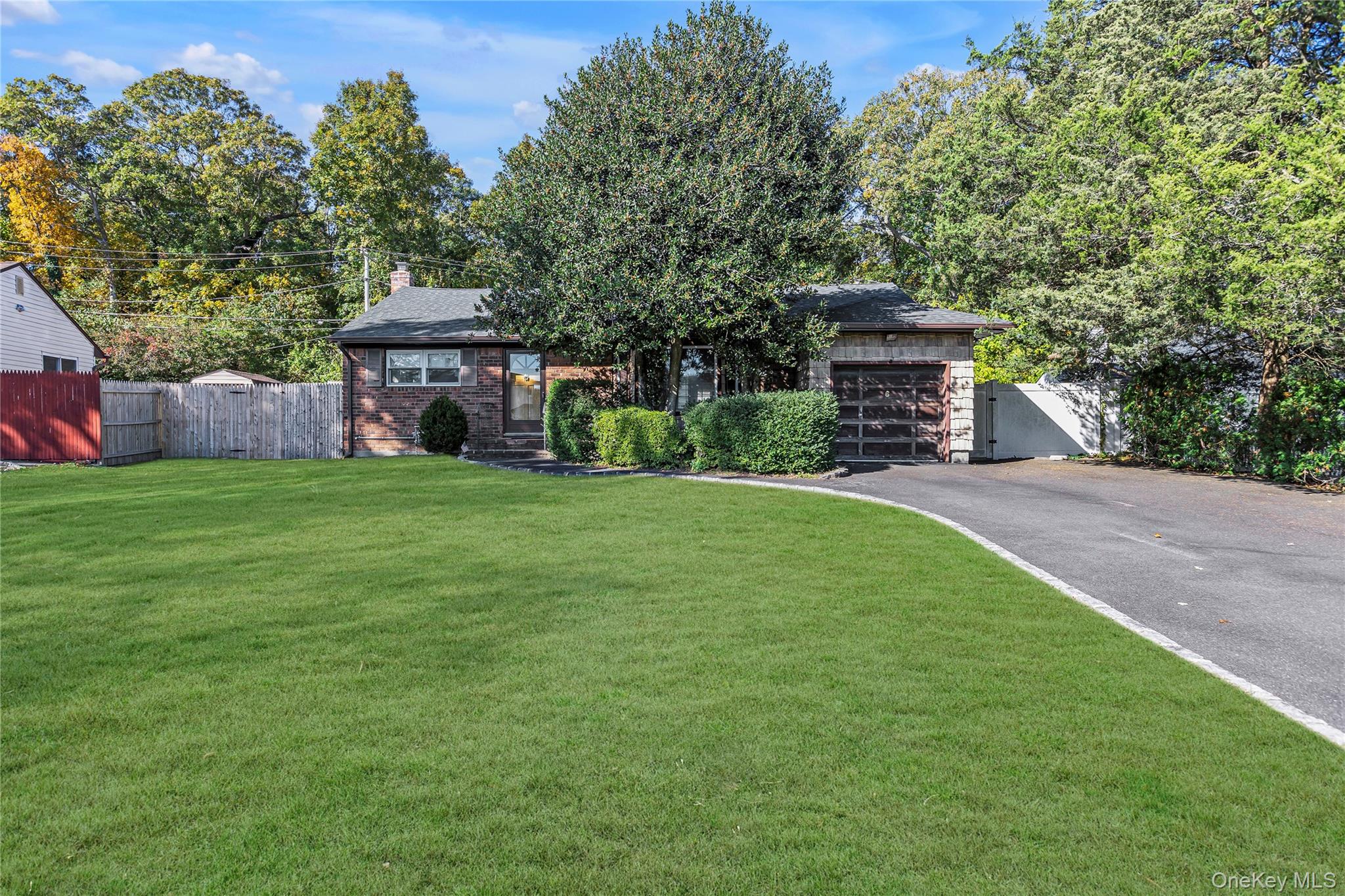 6 Roxbury Drive Commack, NY 11725 - Photo 1 of 1 View of front of house with asphalt driveway, brick siding, an attached garage, a chimney, and view of scattered trees
