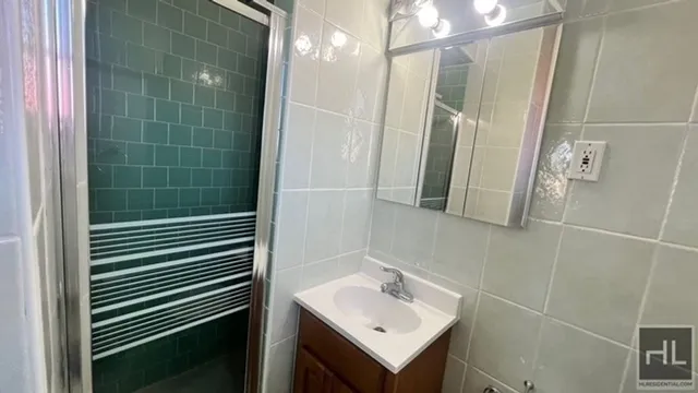 a bathroom with a sink mirror and shower